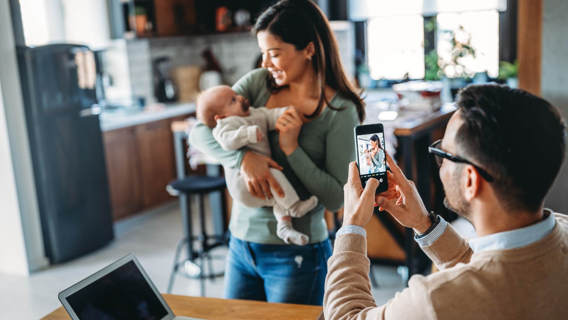 woman who overcompensates in public smiling for a photo with her baby