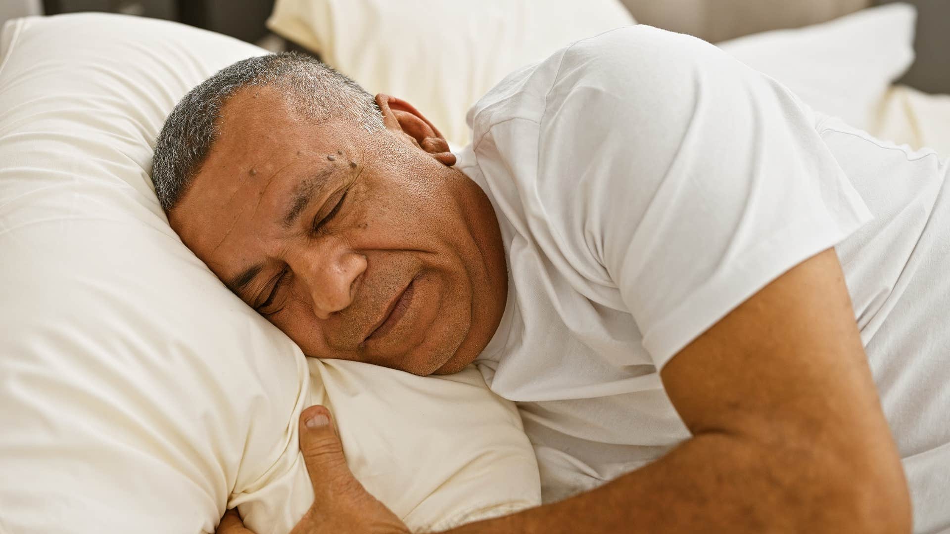 man with a cold unwelcoming exterior asleep in bed