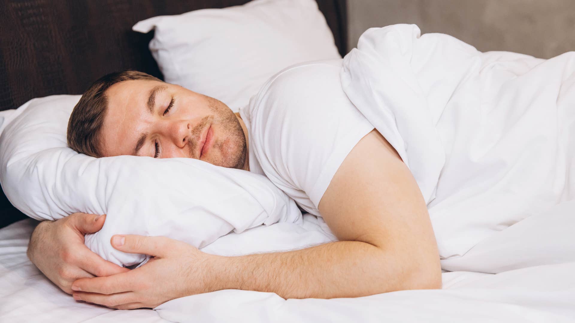 man who's sensitive lying in bed asleep