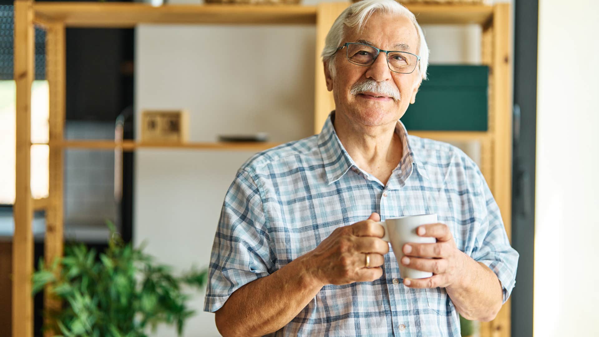 man practicing self-acceptance smiling at home