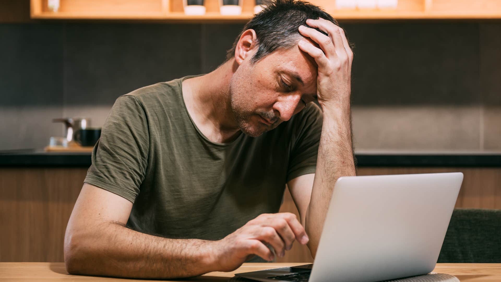 man whose social battery drains quickly looking at his laptop