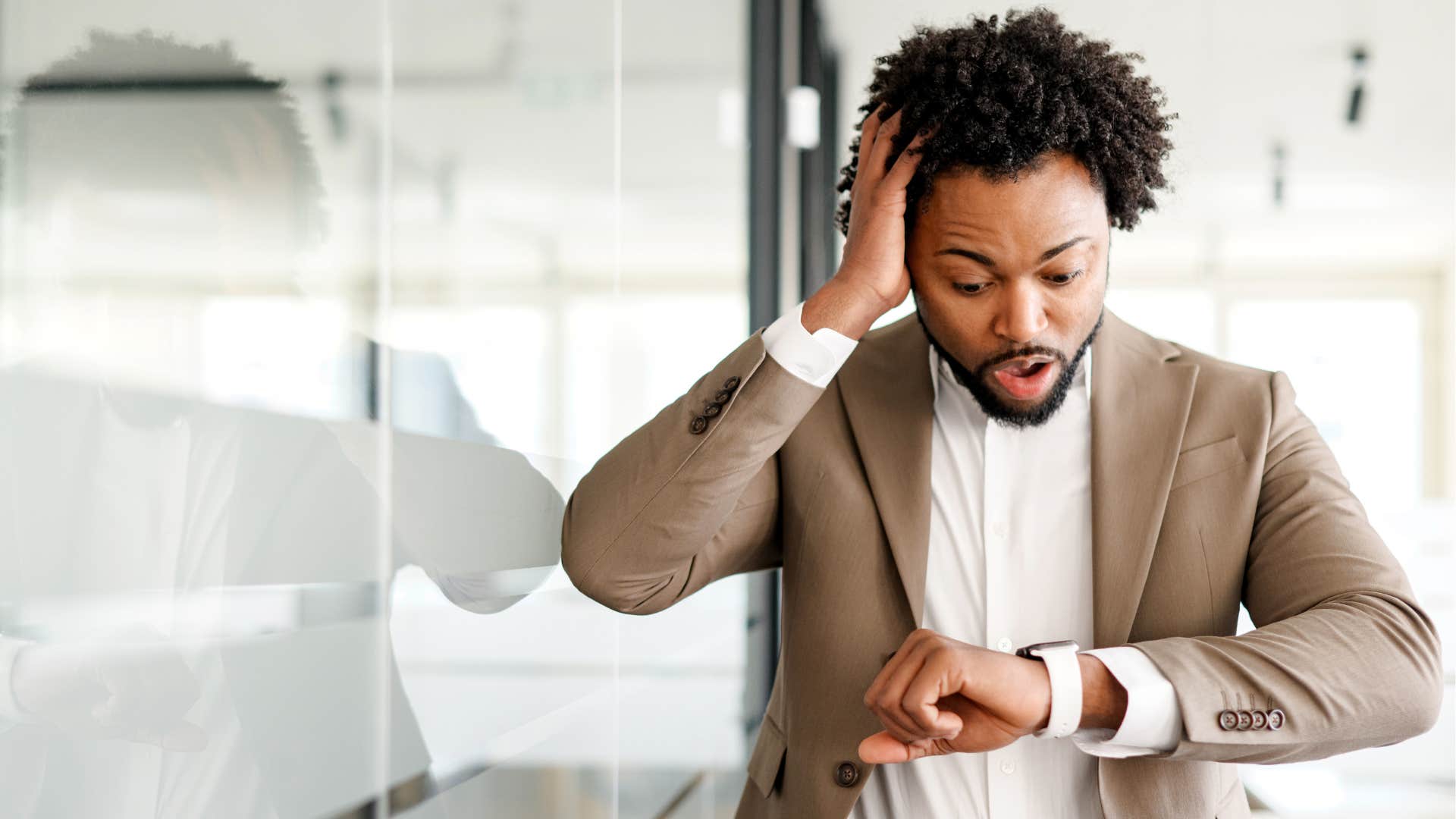 stressed man looking at watch realizing he's late
