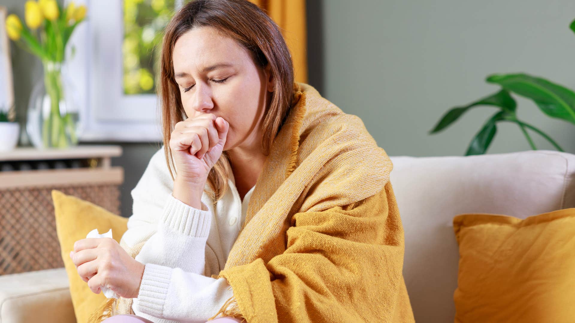 woman battling an illness at home on the couch