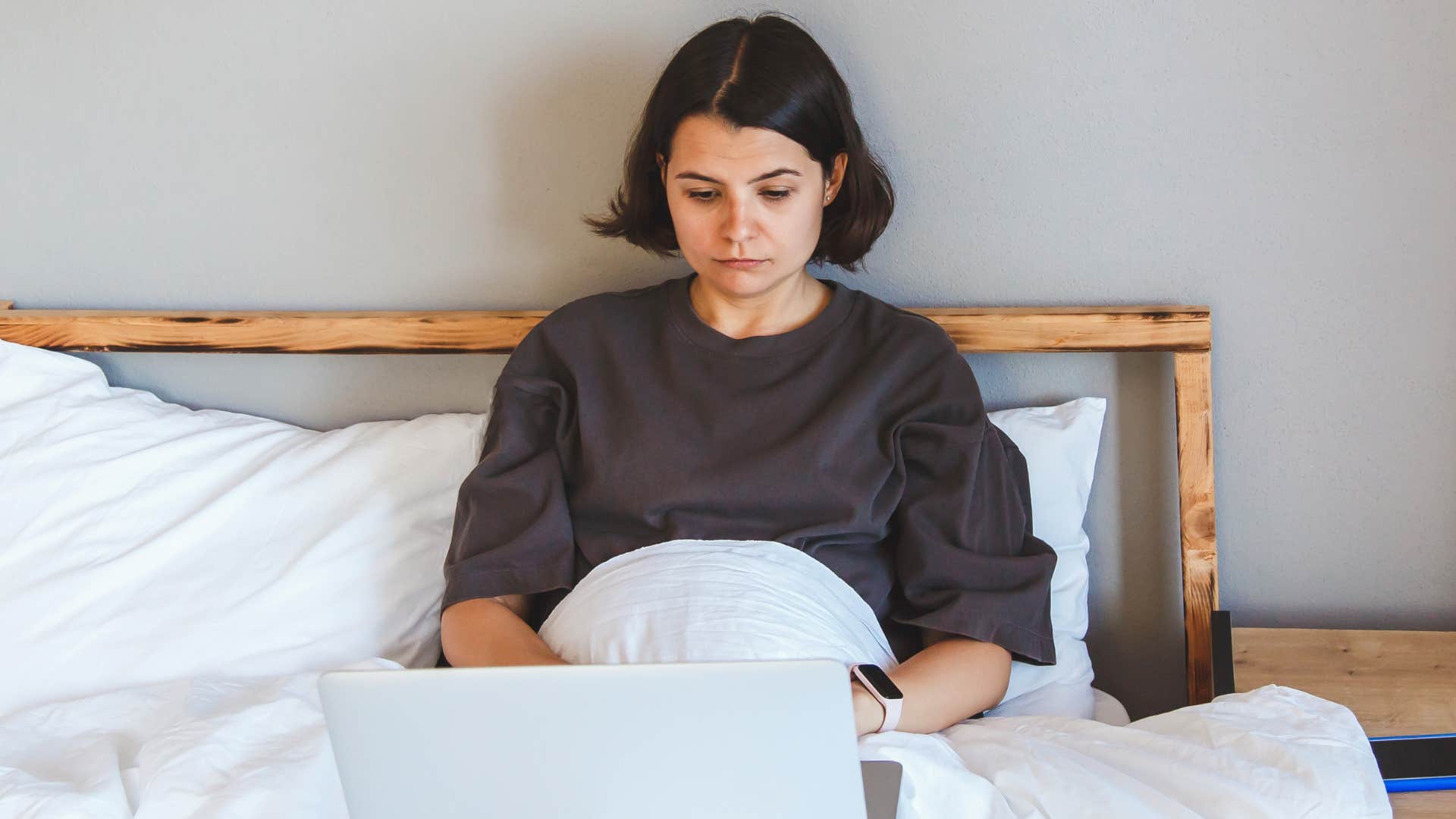woman with morning anxiety working in bed