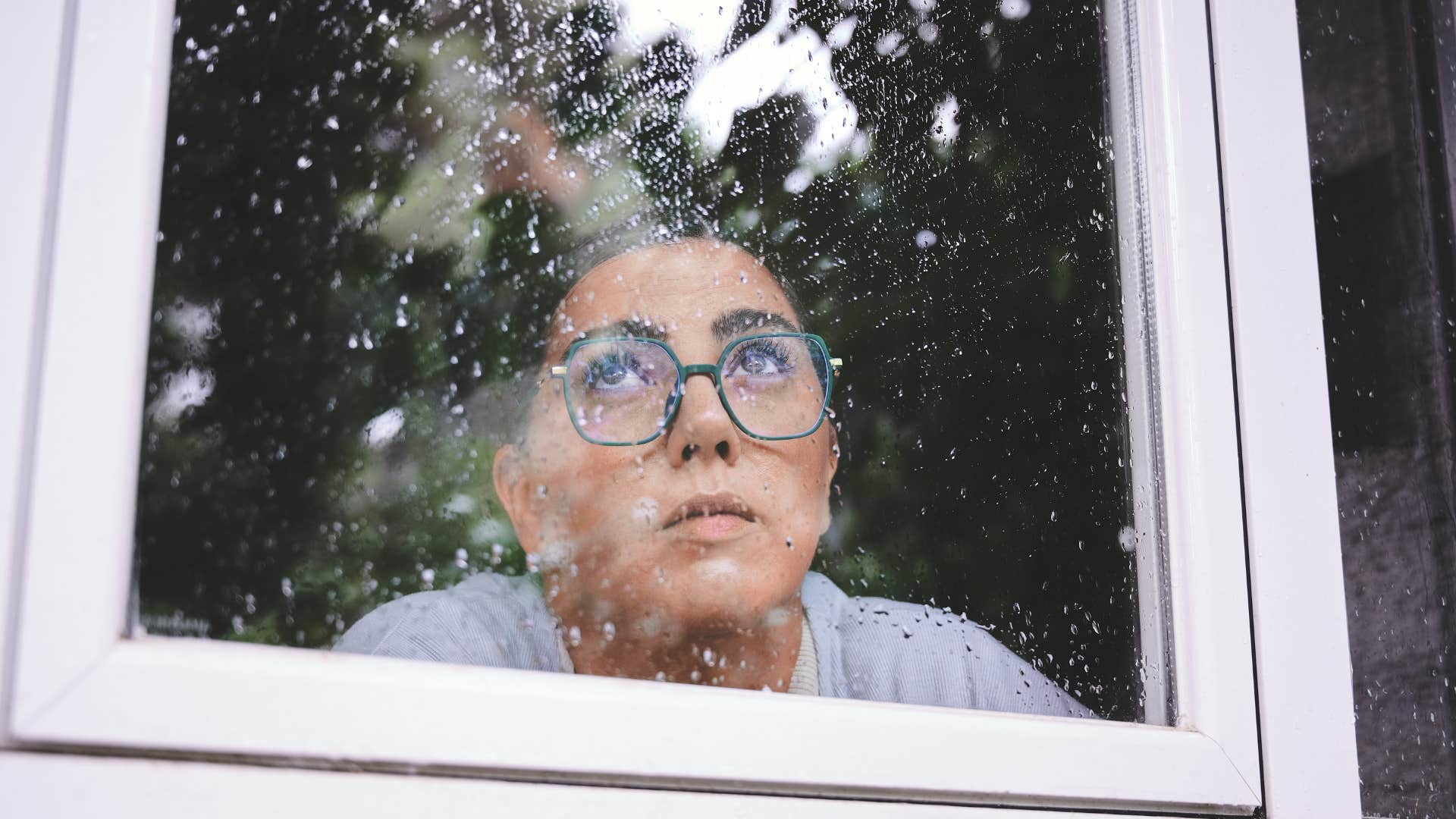woman looking out window seeking a higher purpose