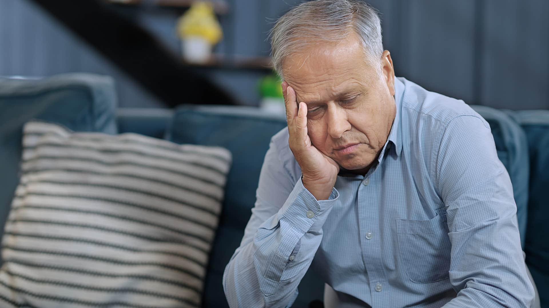 man who feels burdened with the protector role sitting alone at home