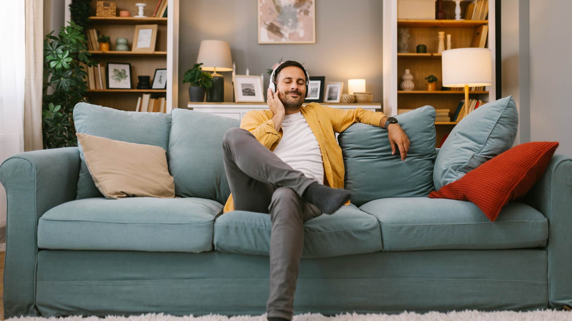 man relaxing on couch listening to music enjoying alone time