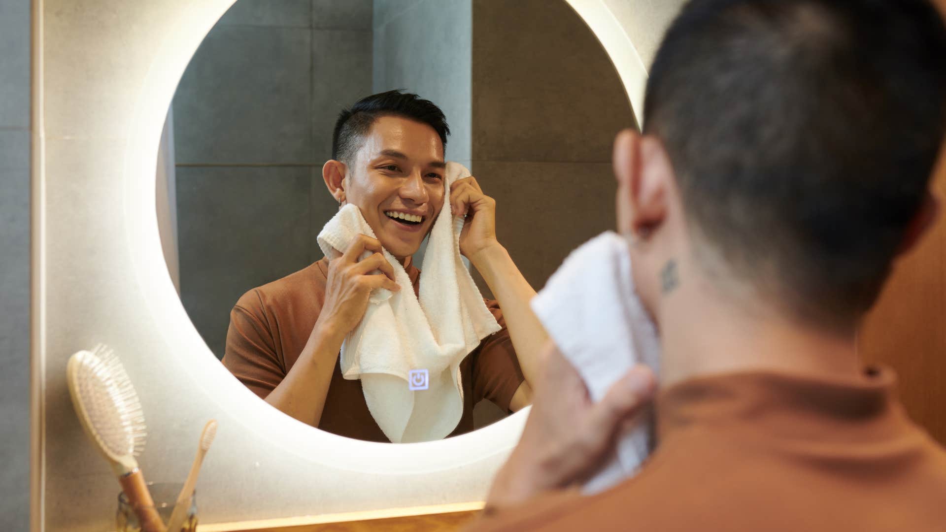 man who appreciates self-care looking in bathroom mirror