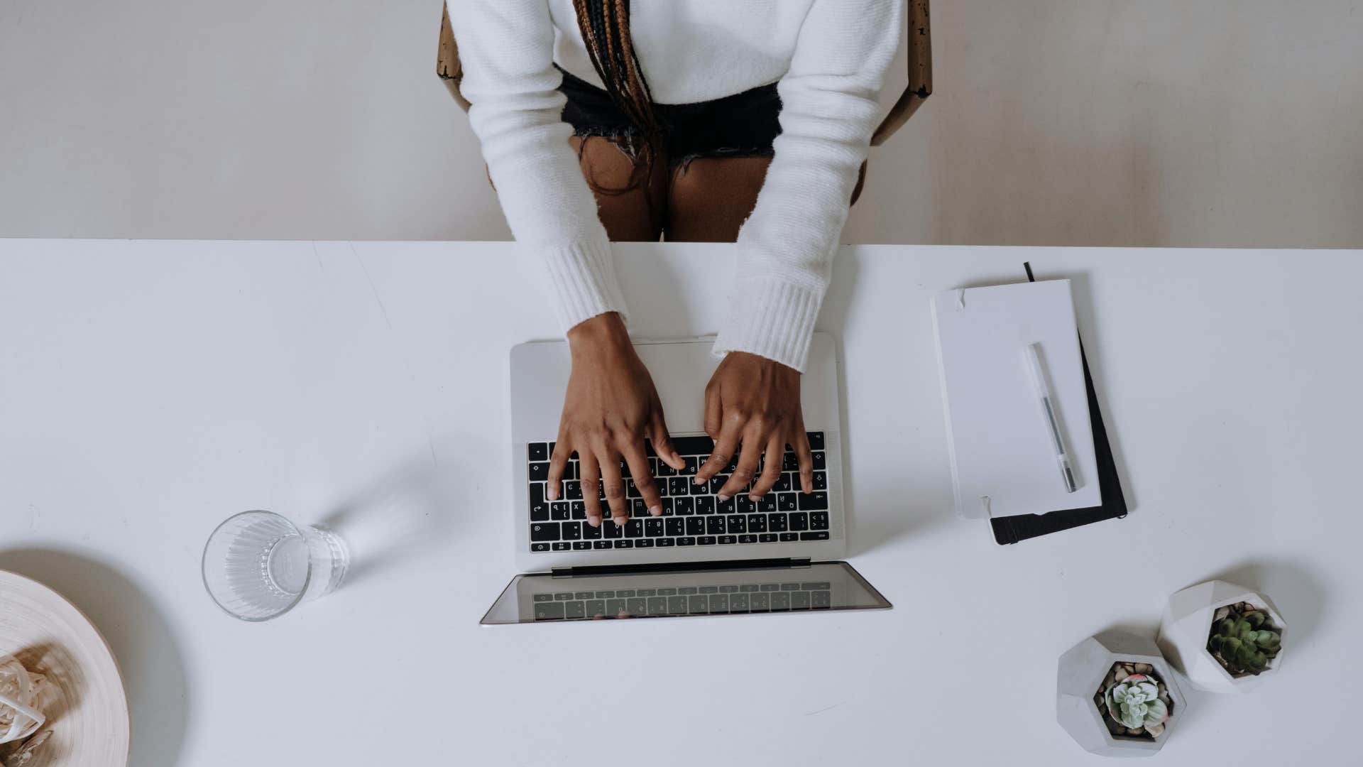 person writing thought essay on laptop
