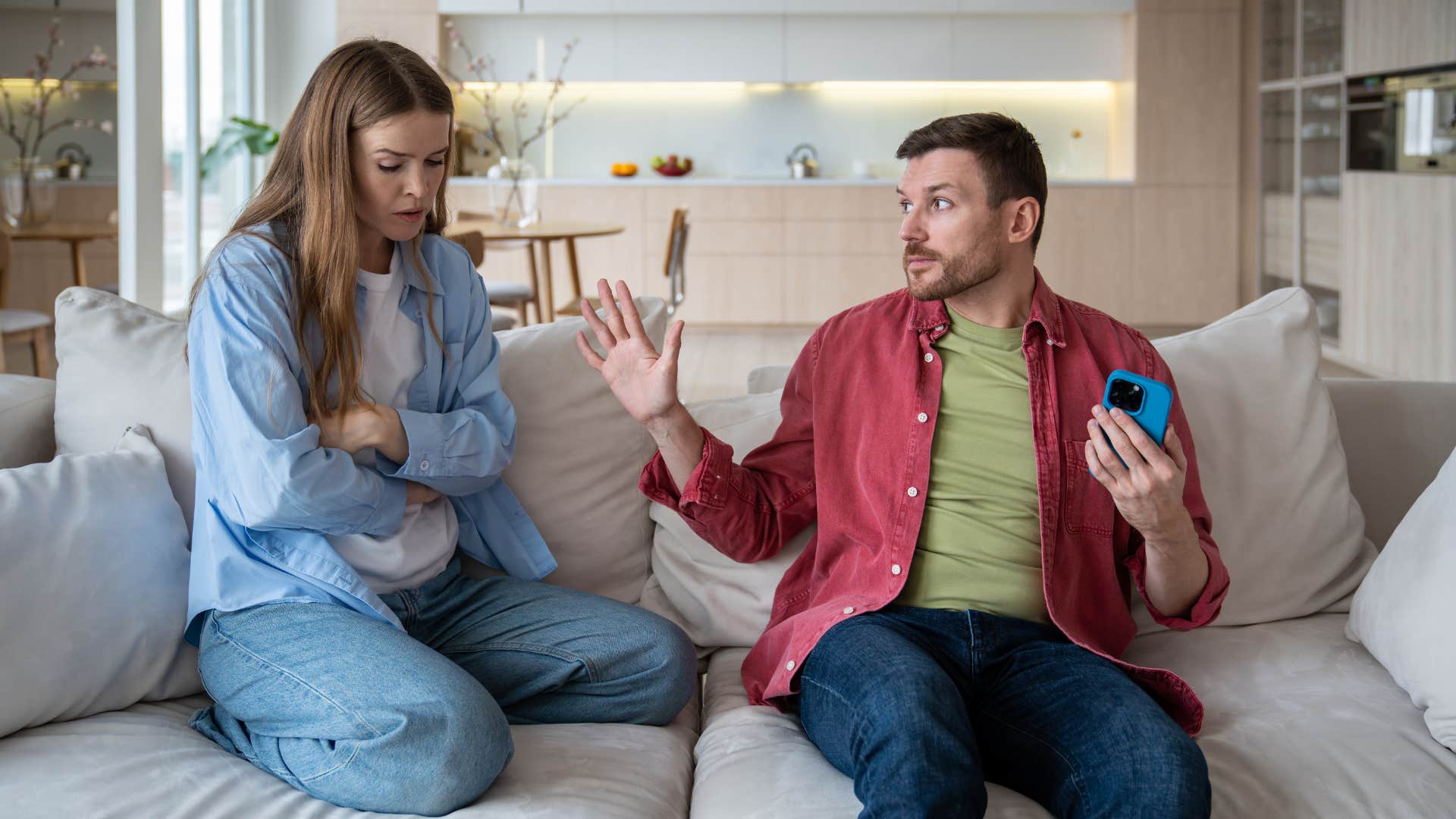 man arguing with woman while on his phone