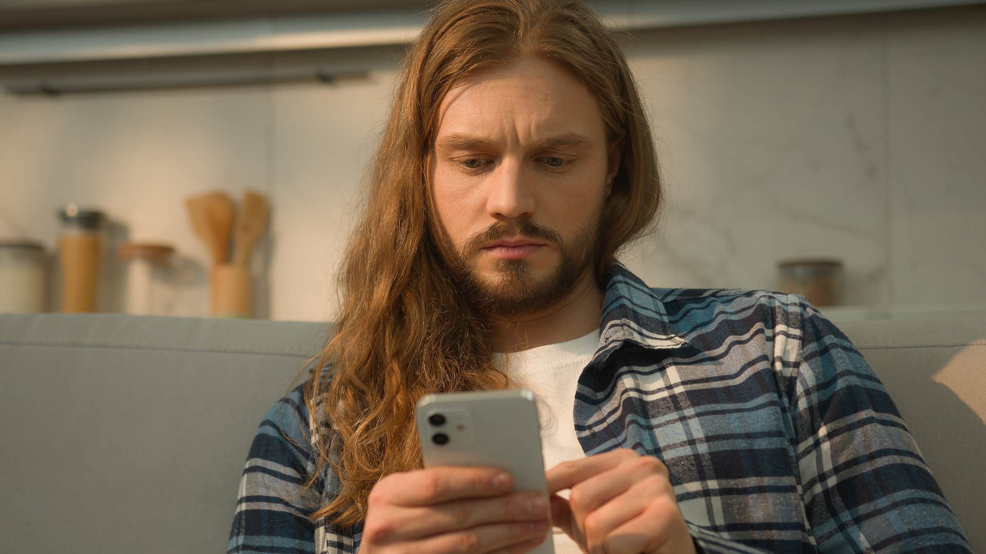 man on his phone posting shade on social media