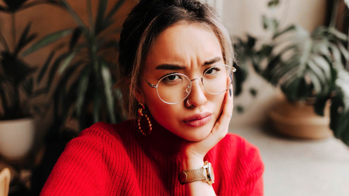 Serious Asian woman in glasses indoors, illustrating psychology skills and mental strategies to help complicated people simplify their thoughts