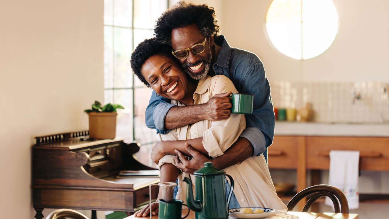 husband holding his wife in a tight hug at the breakfast table