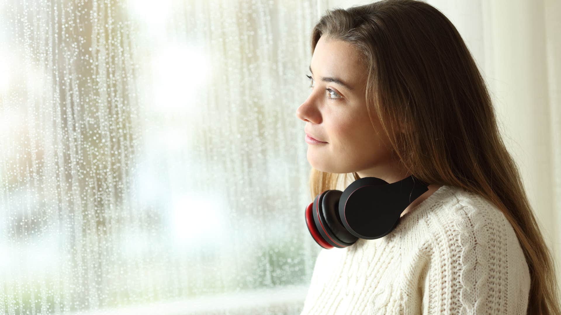happy woman enjoying healthy solitude looking out a window