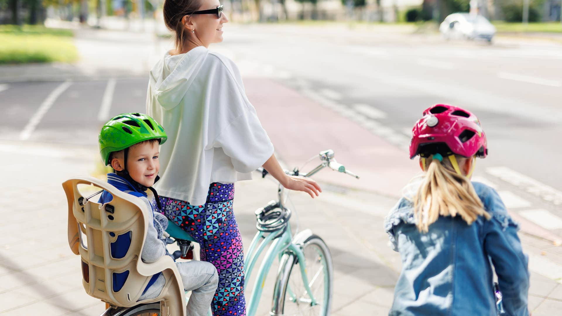 woman who is naturally good mom as she leaves house to go for a bike ride