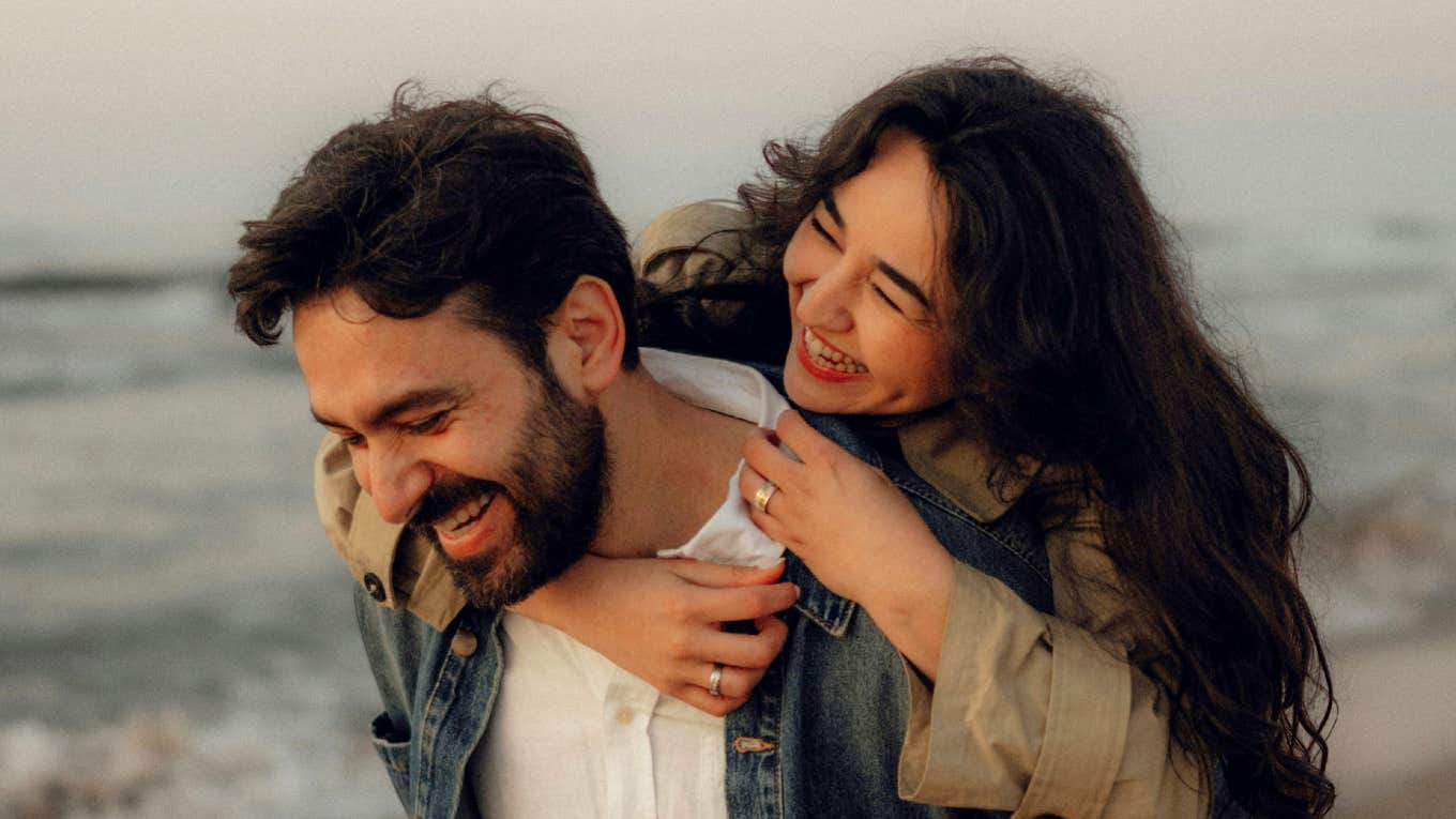 Wife sharing a warm moment with her smiling husband showing the simple tricks that make husbands much happier according to a clinical psychologist.
