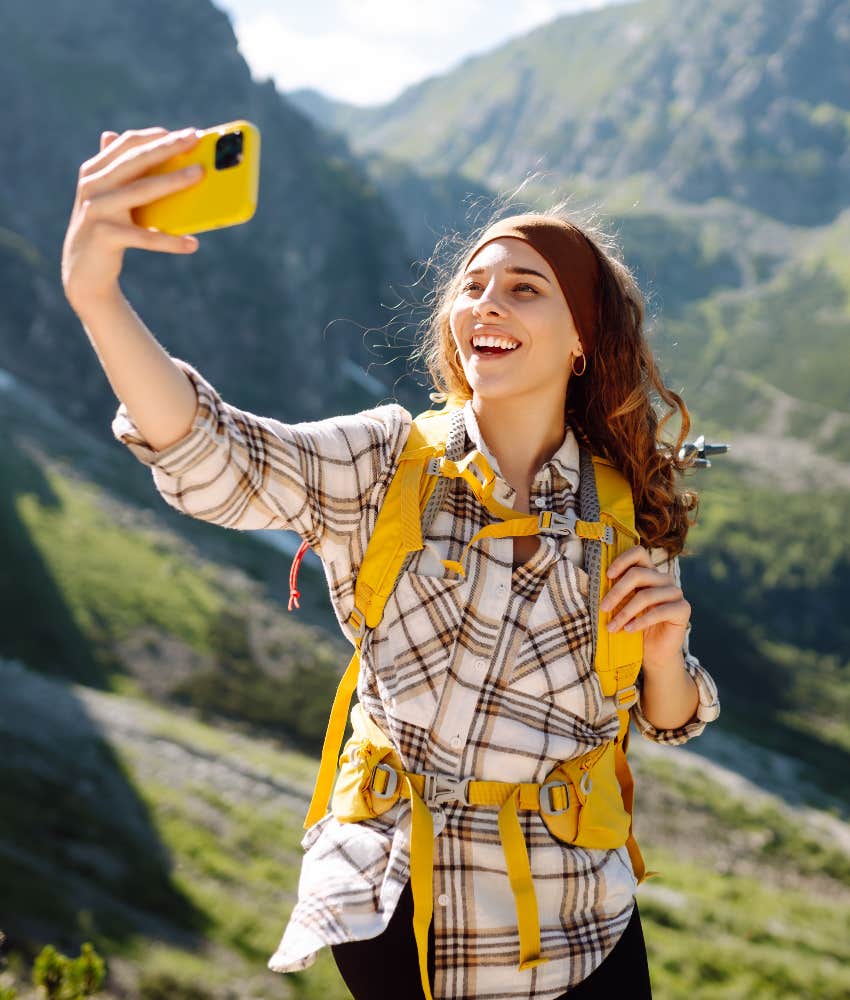 woman taking smartphone picture on hike