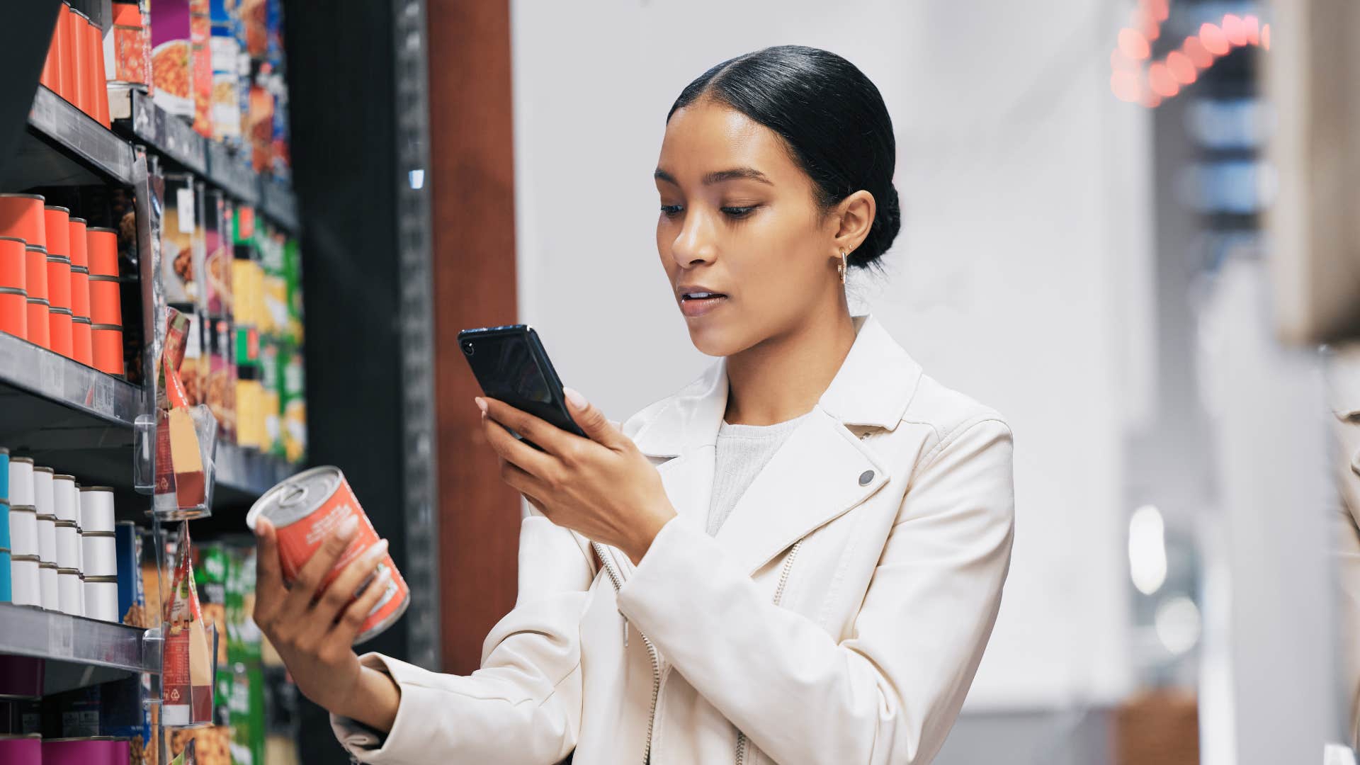 woman checking can price as she doesn't want to overspend for no reason