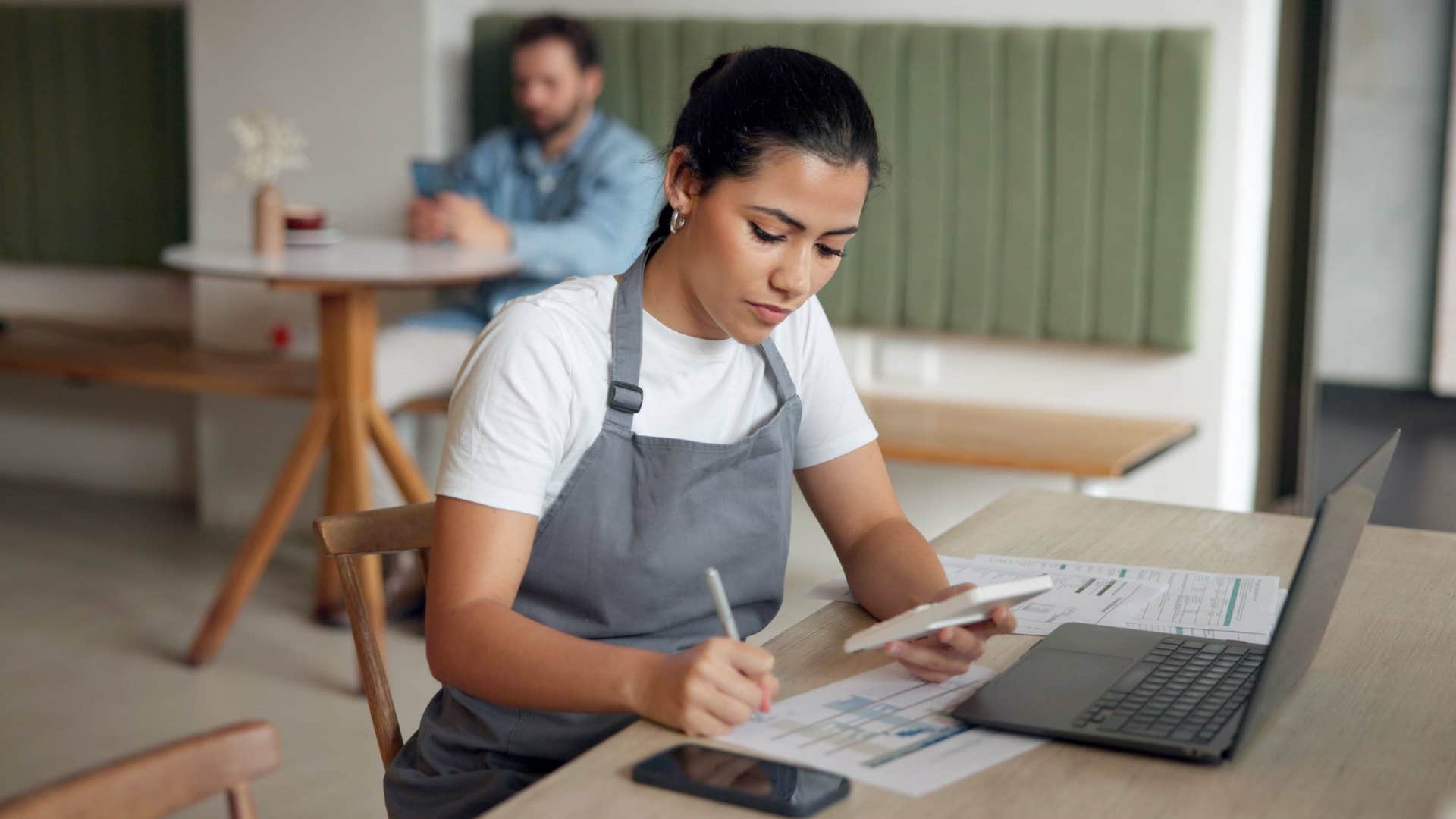 woman in gray apron tracking business expenses