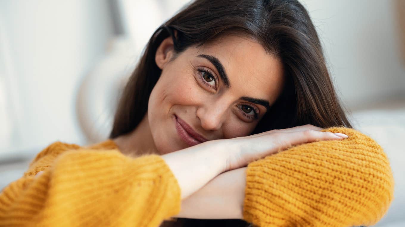 happy woman who stopped posting on social media relaxing at home