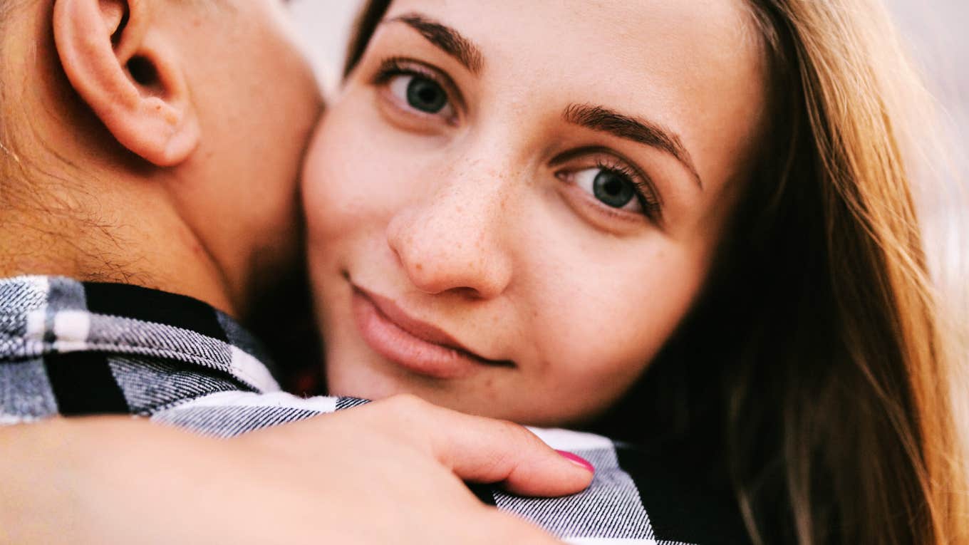 Focused woman with a couple embracing showing why people like who they like romantically and the evolutionary reasons behind attraction.