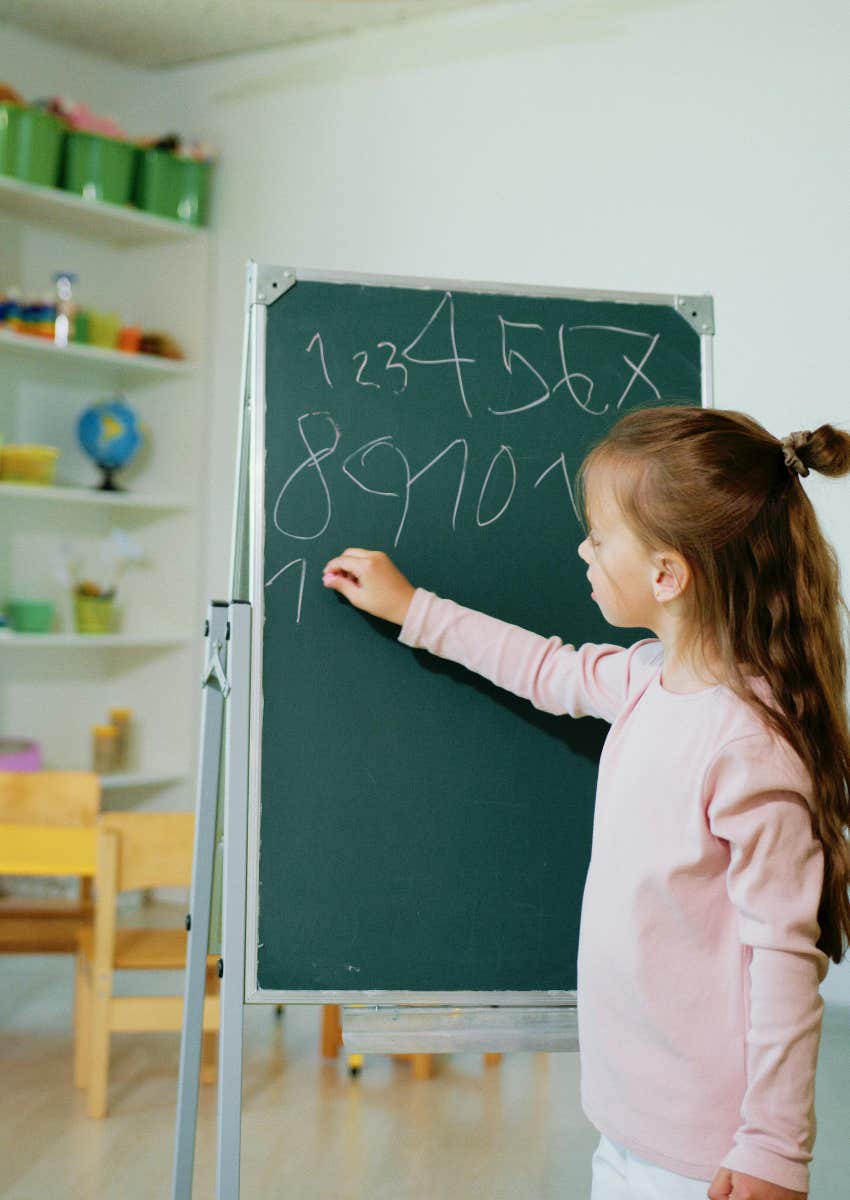 elementary school student doing math on a chalkboard