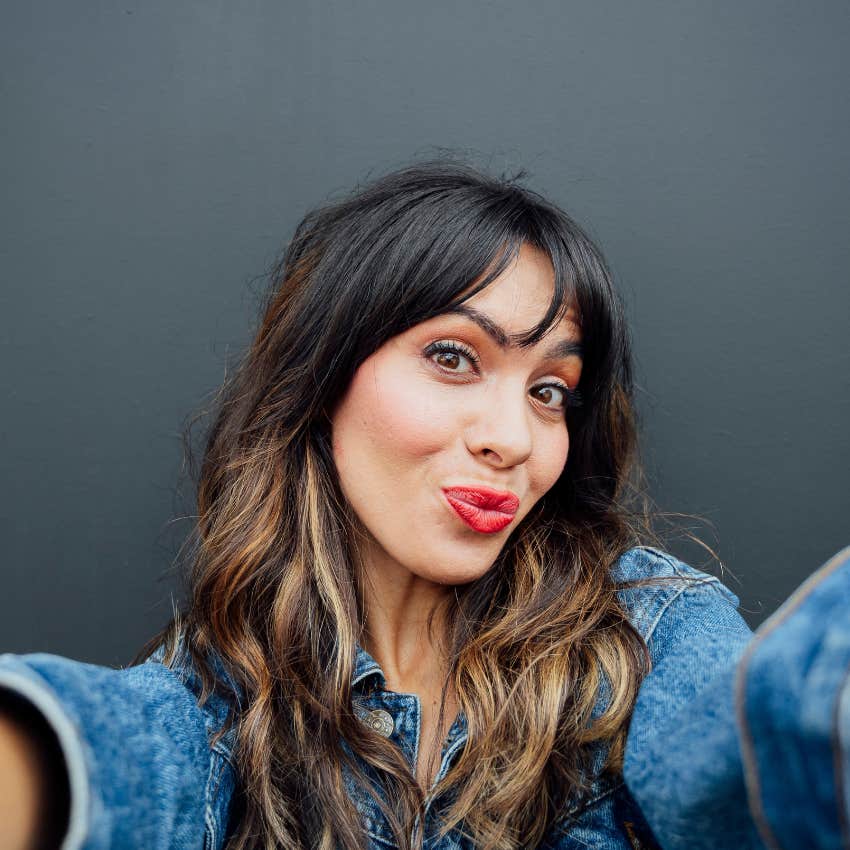 woman taking a profile pic of her not laughing that will make men swipe right