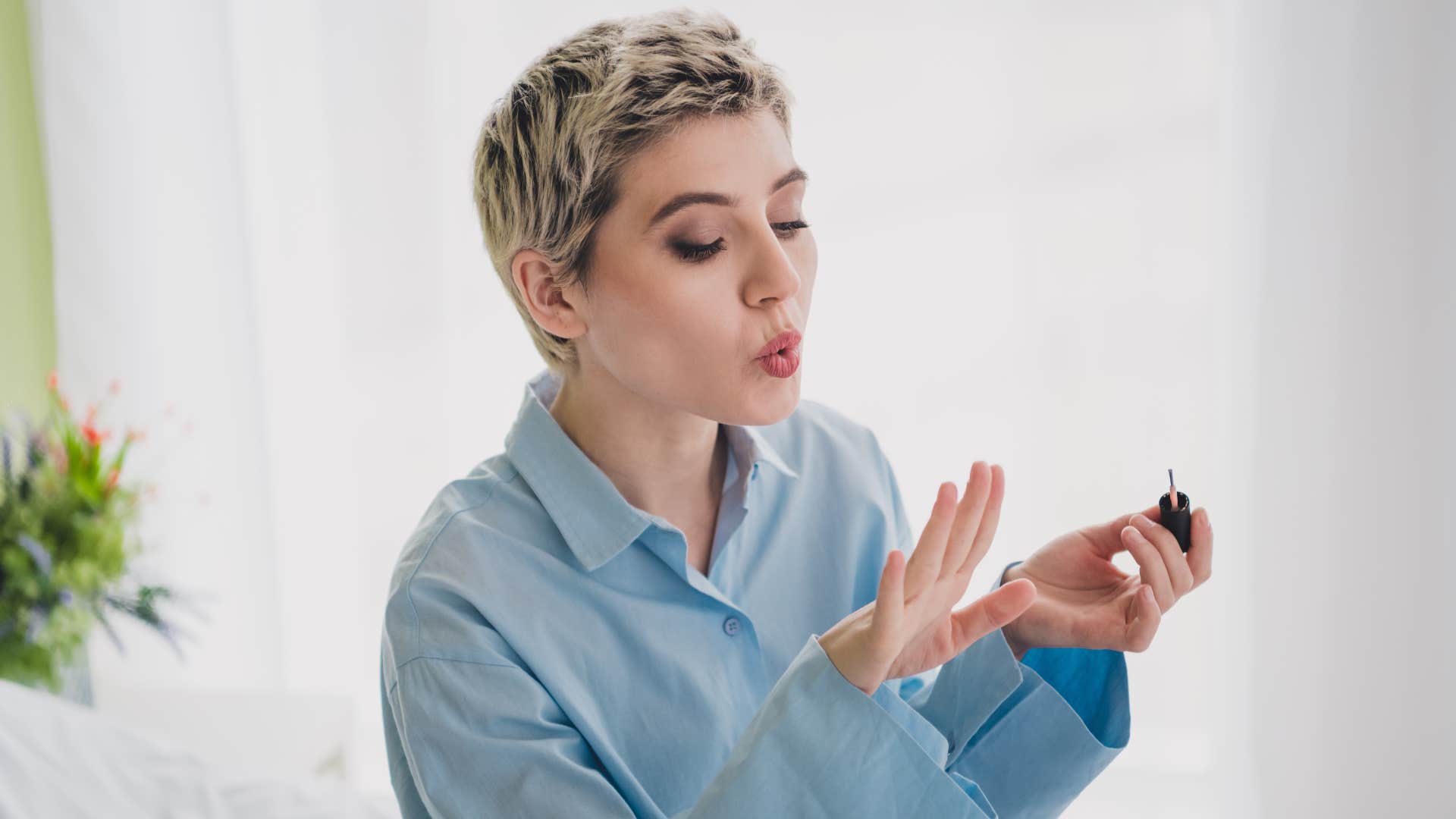 frugal woman giving herself a manicure at home