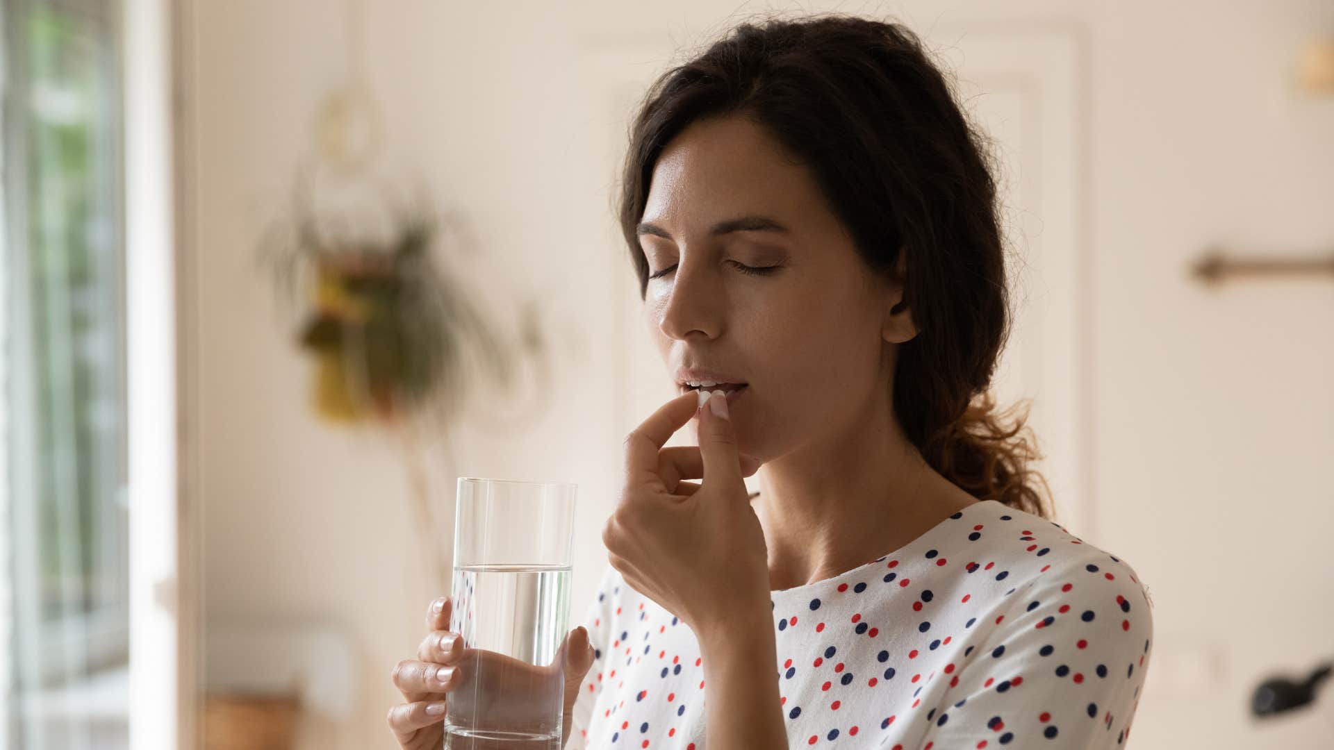 woman taking medicine with water