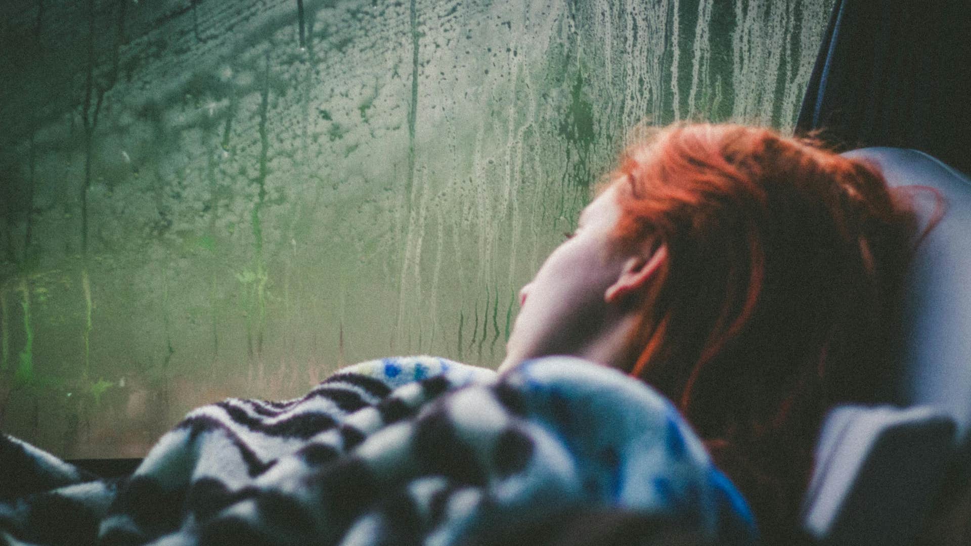person watching a rainy day by window