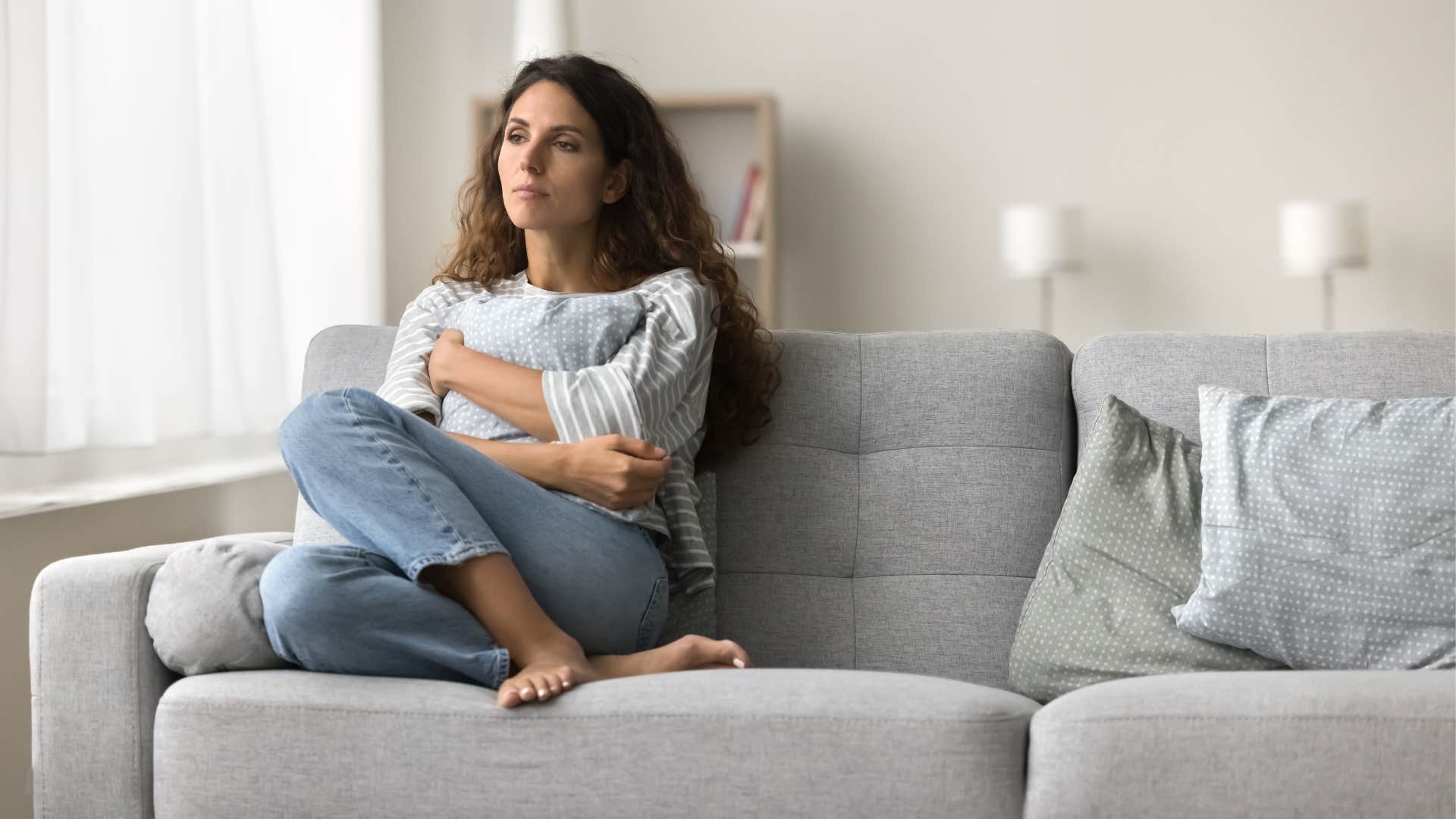 unhappy woman sitting at home on her couch