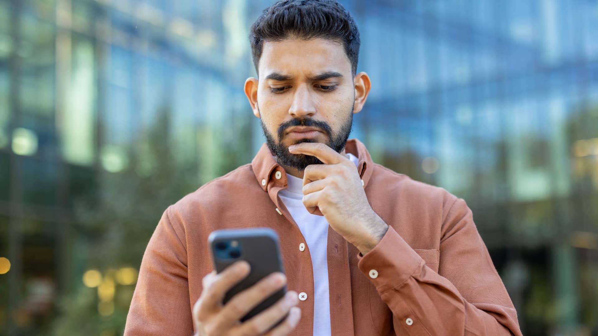 Man staying in toxic group chats looking at his phone.