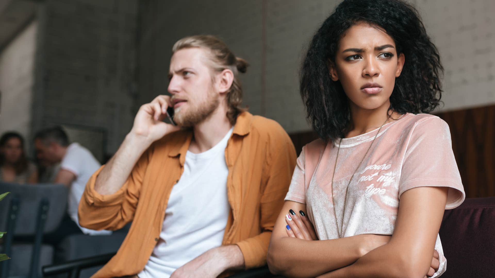 Man holding his phone and using it as a distraction from his wife.