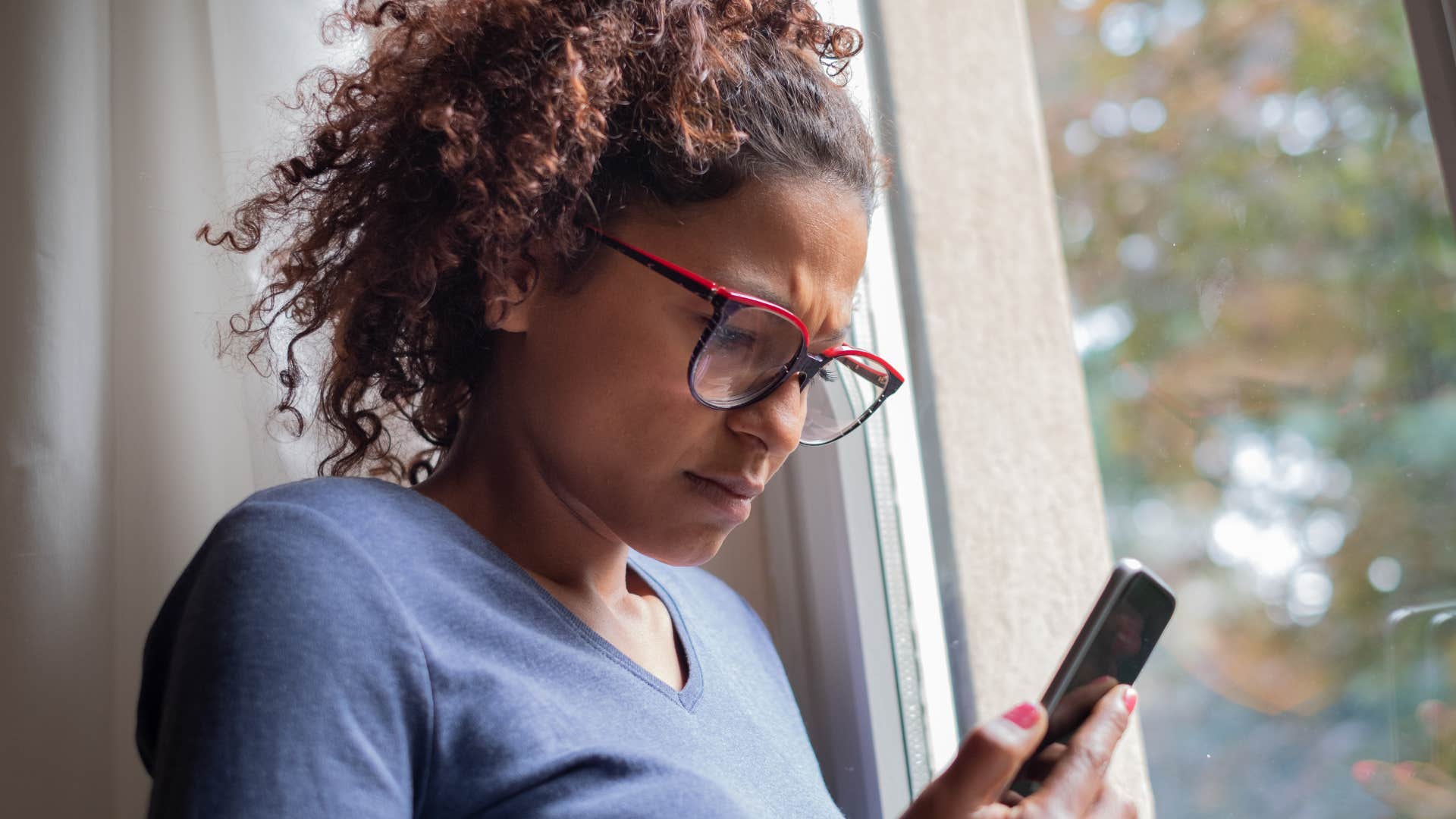 Woman working on her phone at home.