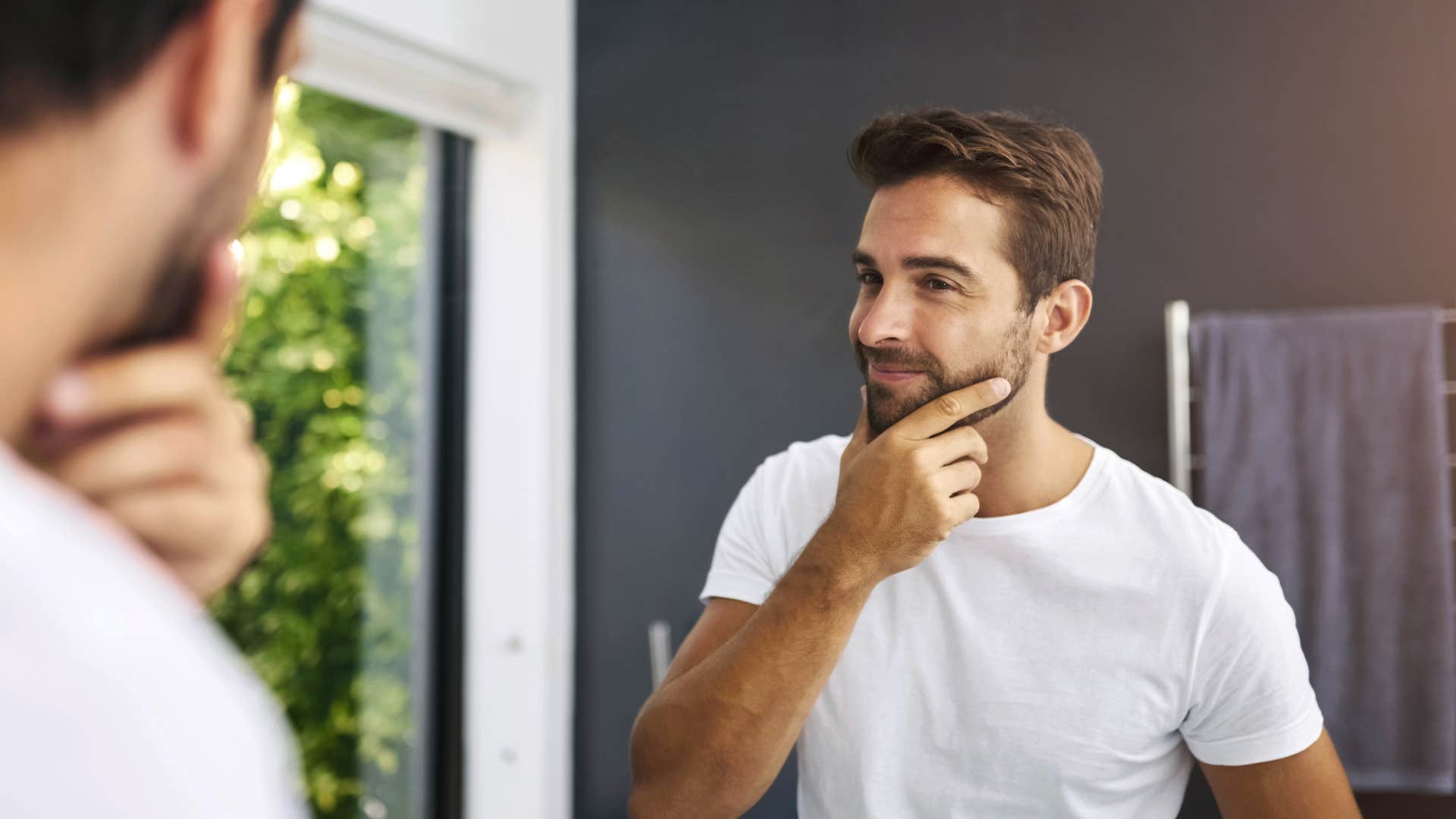 man looking in the mirror looking confident
