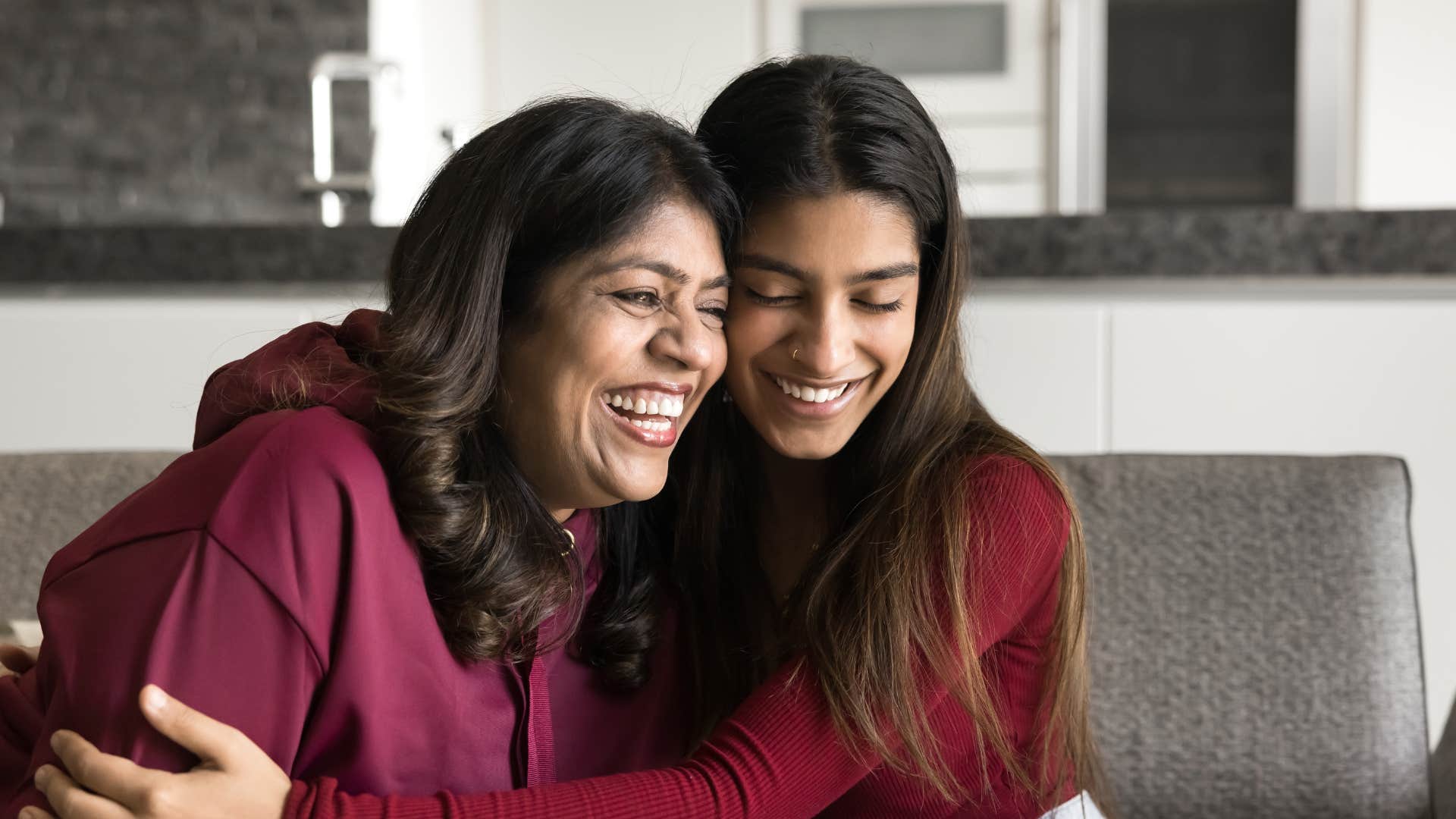 adult daughter hugging her mom smiling