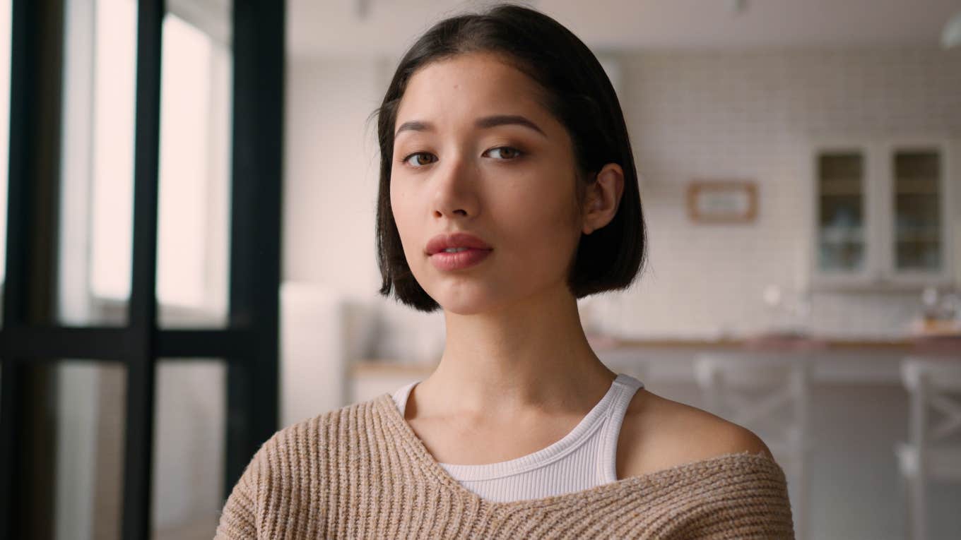 street smart woman standing in her kitchen thinking
