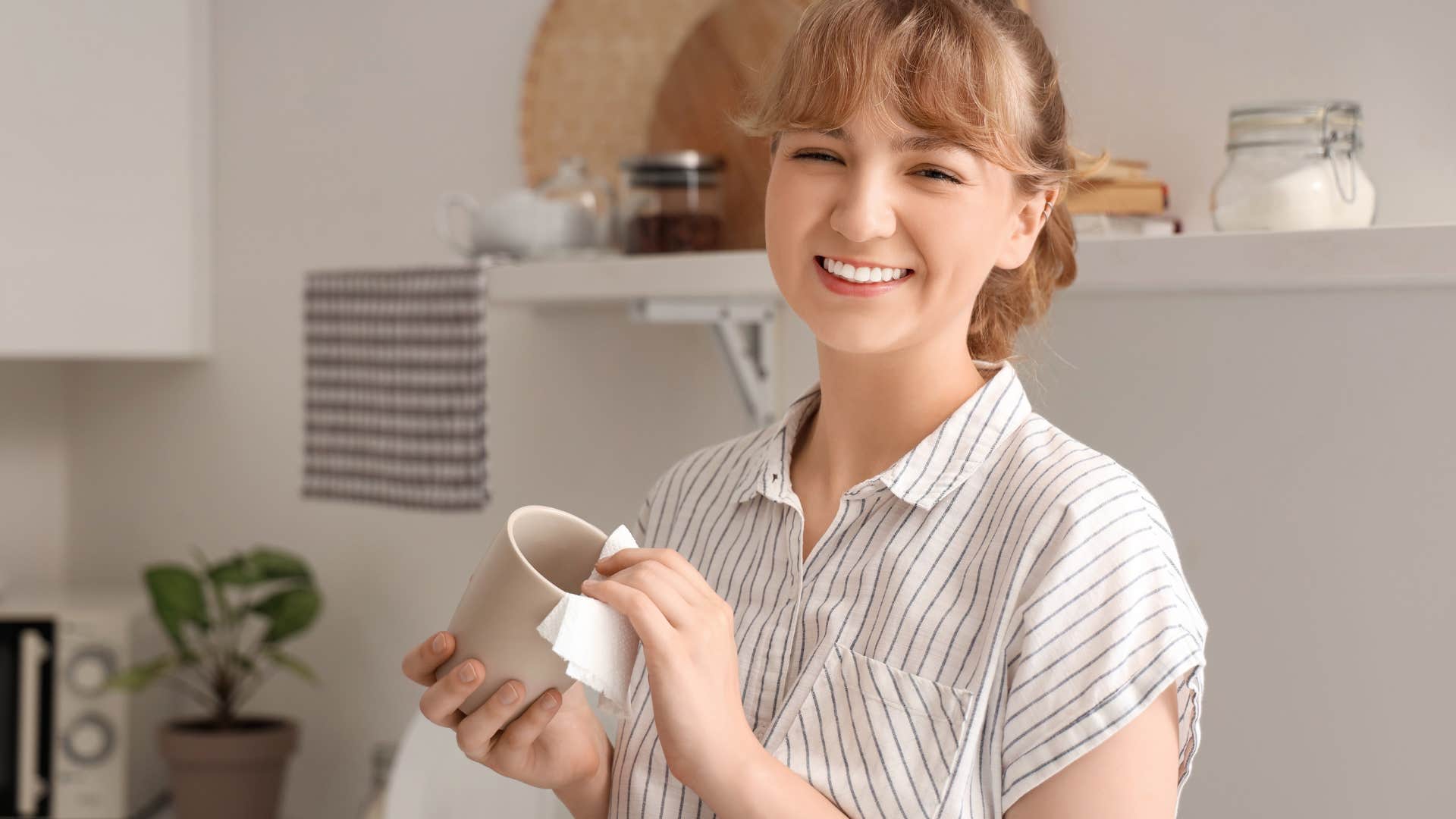 woman polishing cup in her kitchen