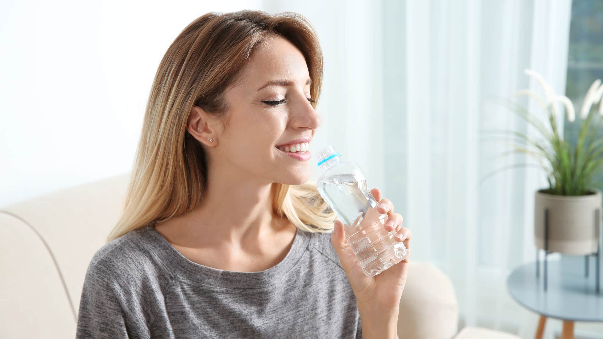 woman drinking from water bottle