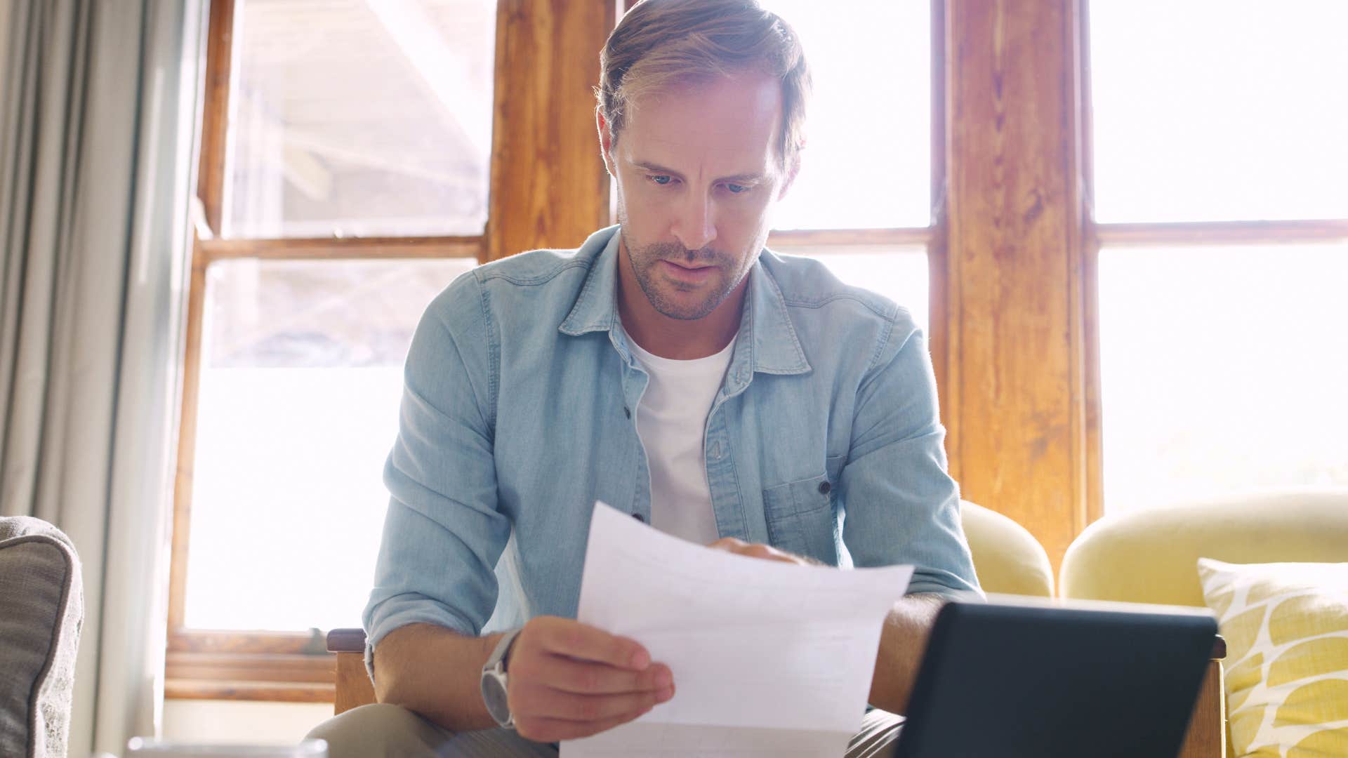man looking at confidential work papers at home