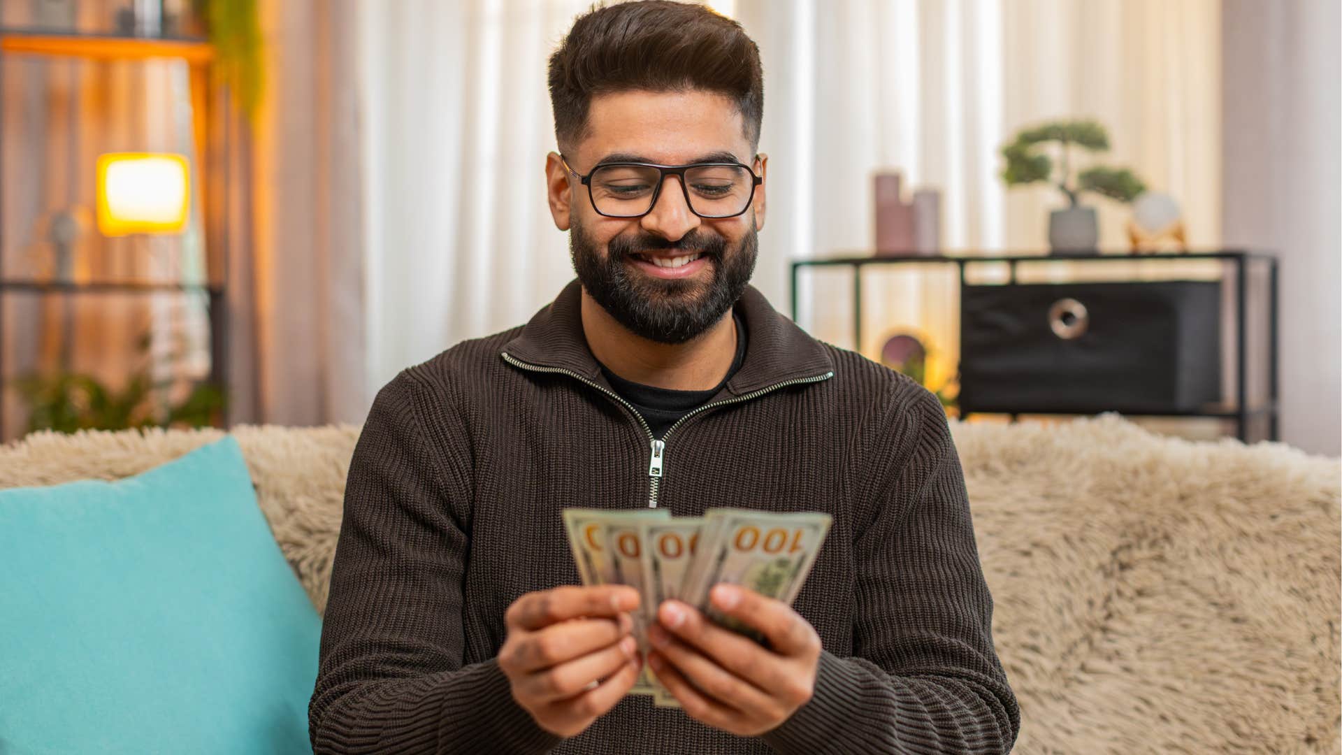 man holding extra cash for his sock drawer at home