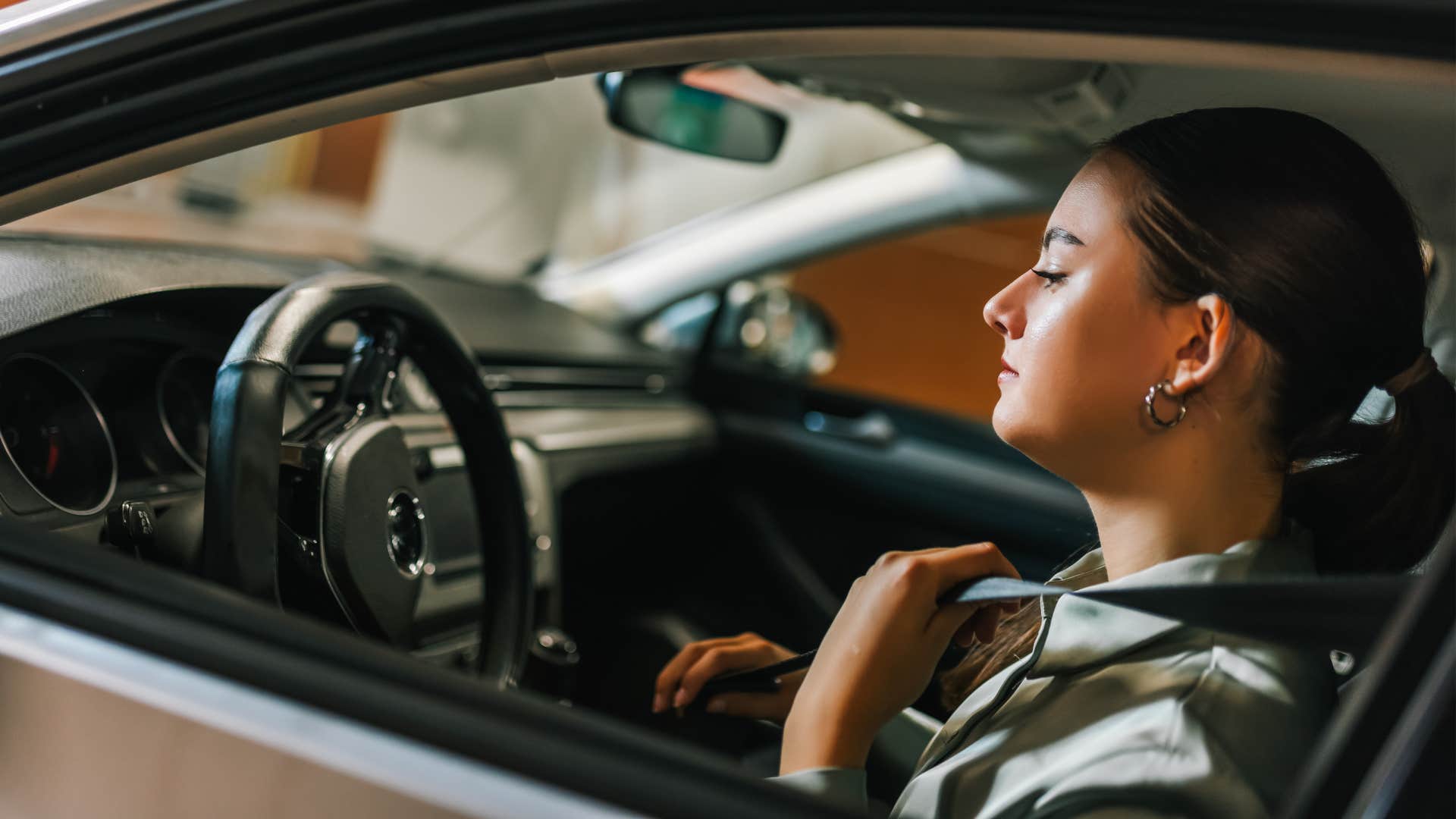 woman using a garage door opener in her car