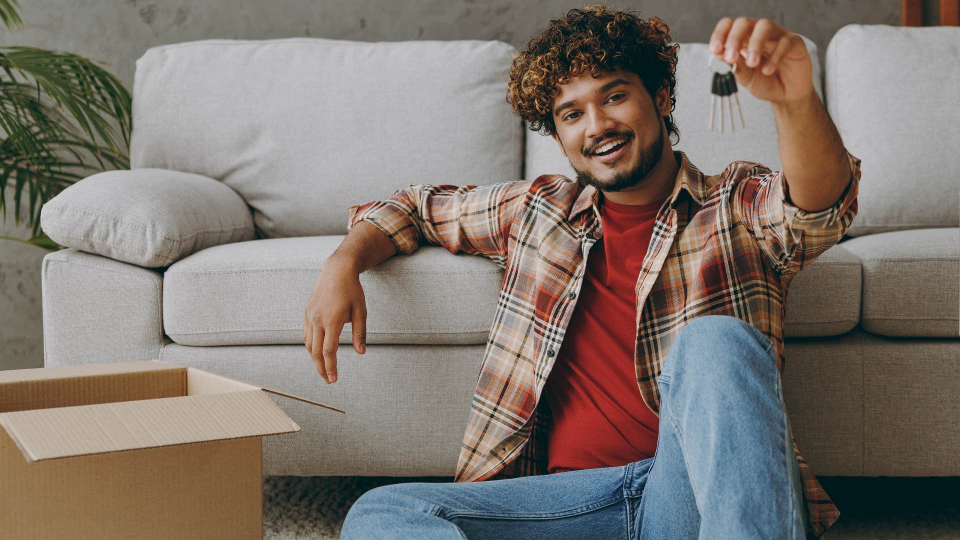 man holding spare set of keys at home