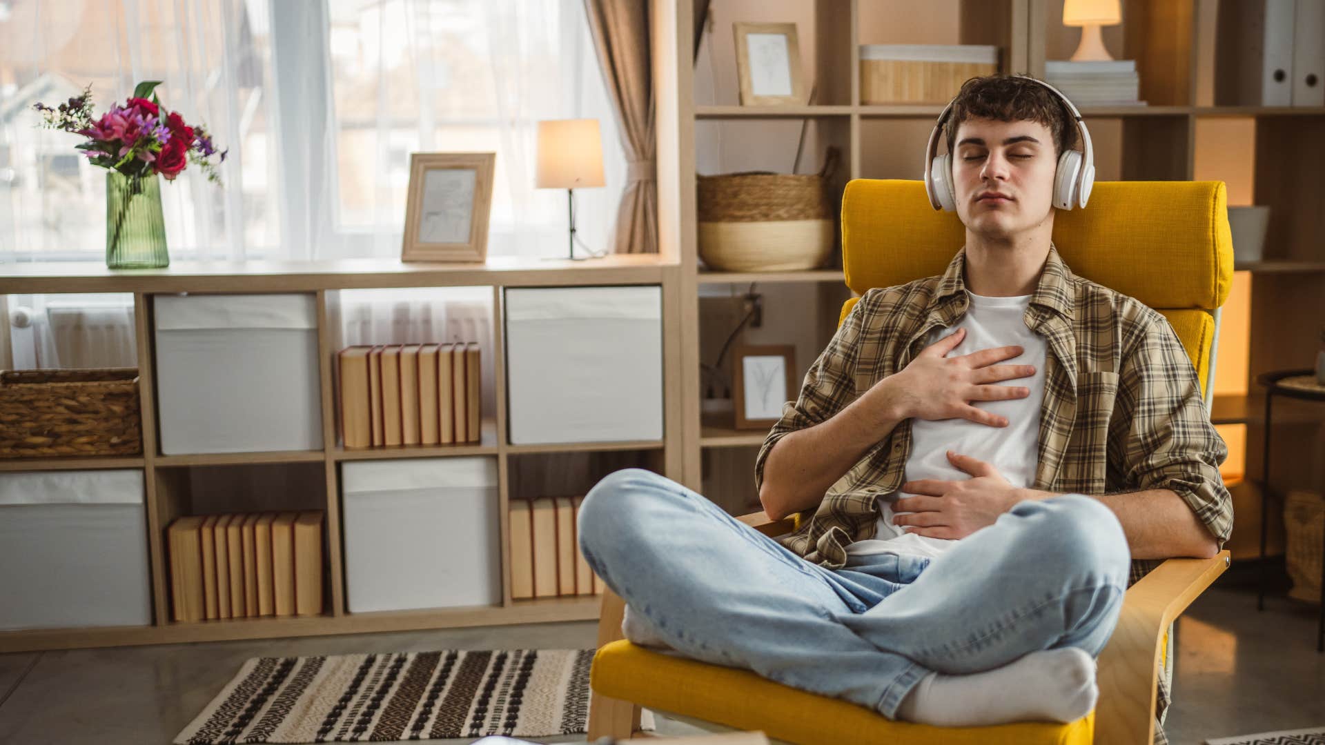 young man taking deep breaths wearing headphones