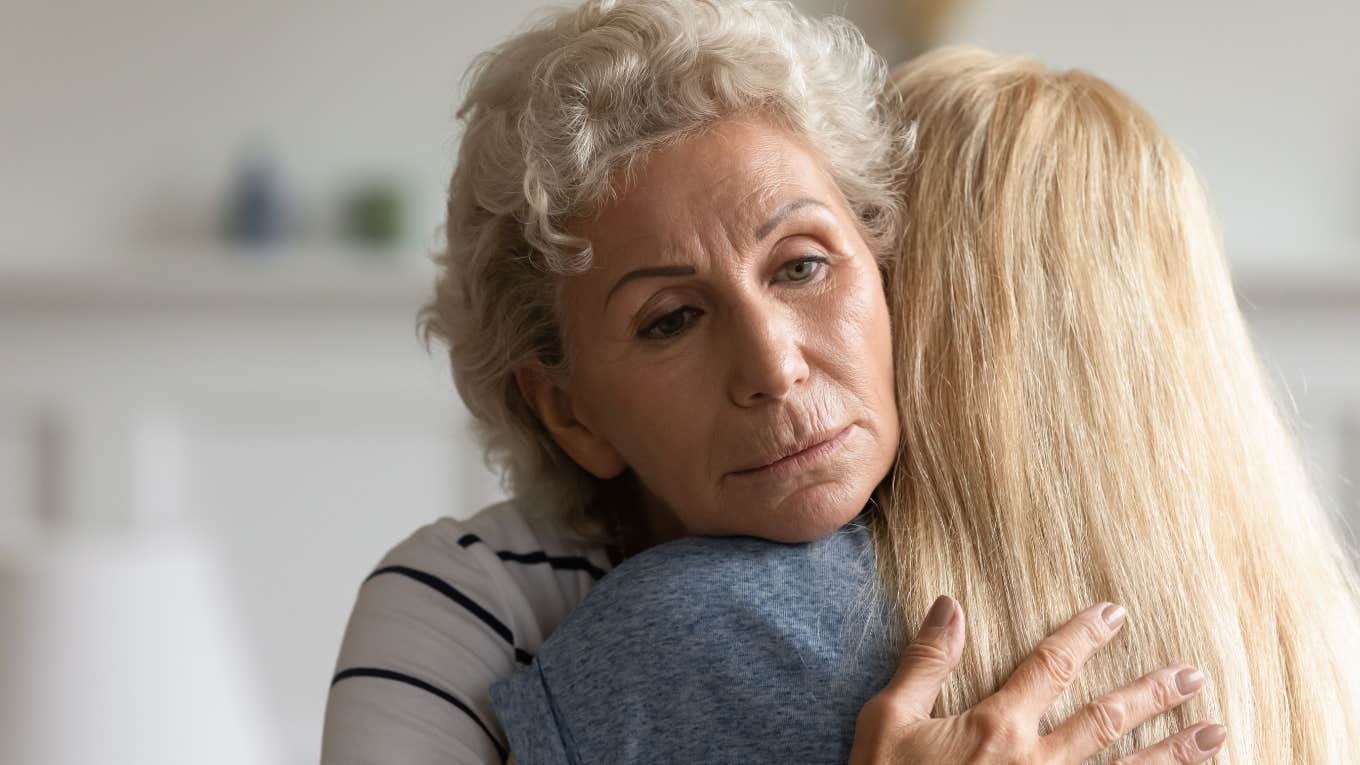 sad older woman hugging adult daughter