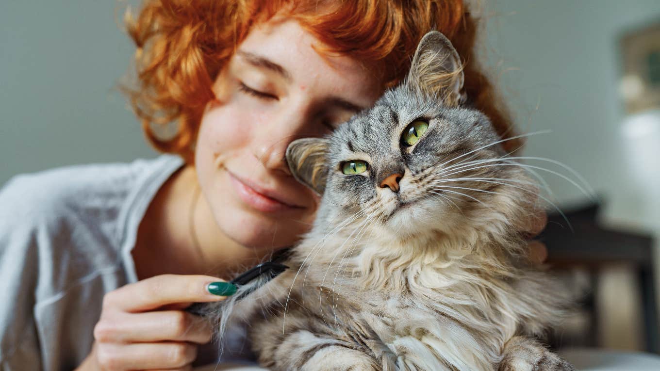 woman cuddling up to guardian spirit cat