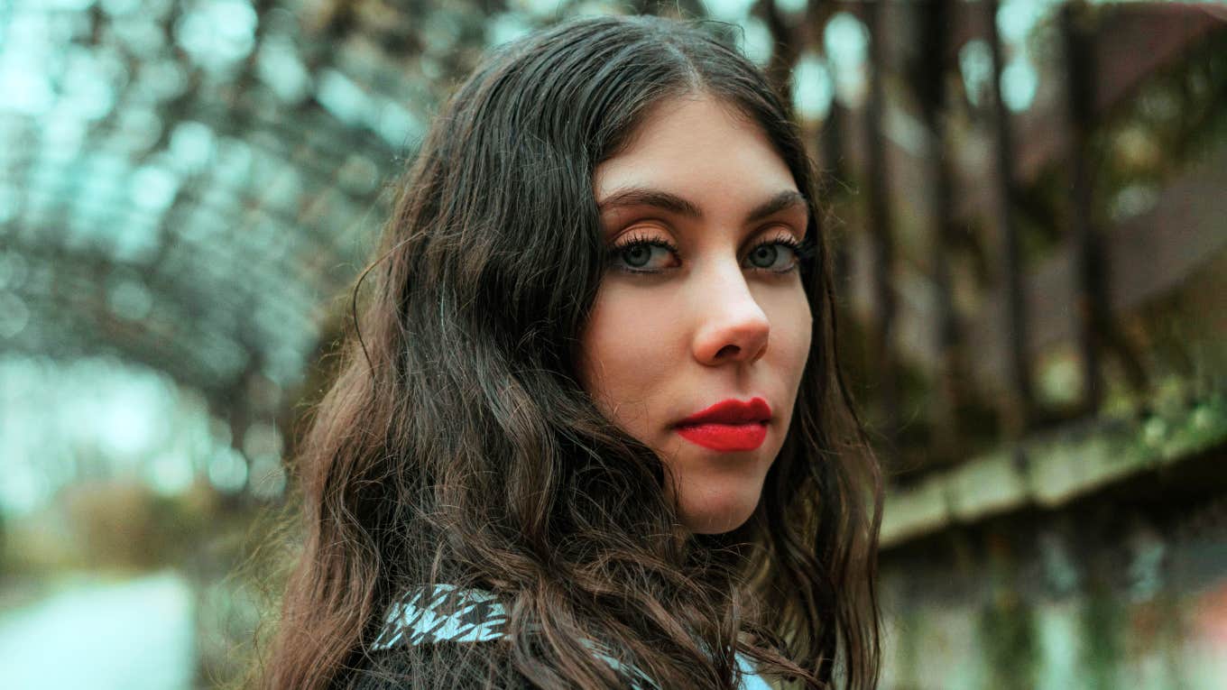 A serene, intuitive woman gazes ahead under a metal frame, capturing the mystery and beauty of discovering psychic abilities and inner power.