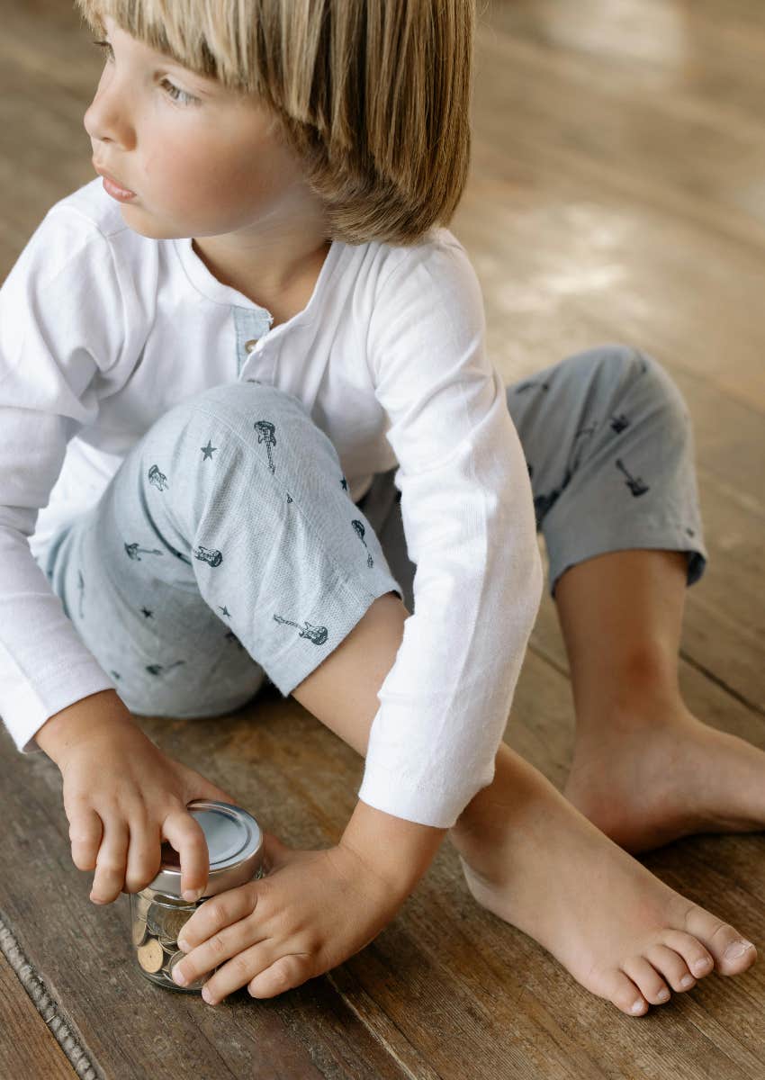middle class little boy saving money in a jar