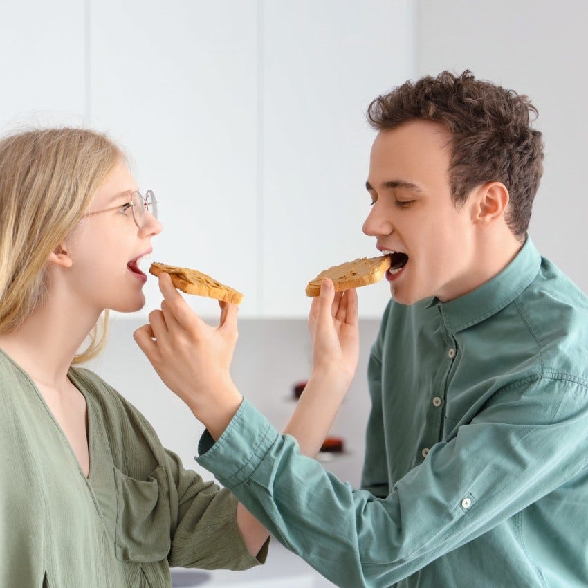 couple doing the weird thing of enjoying peanut butter together as they are perfect for each other
