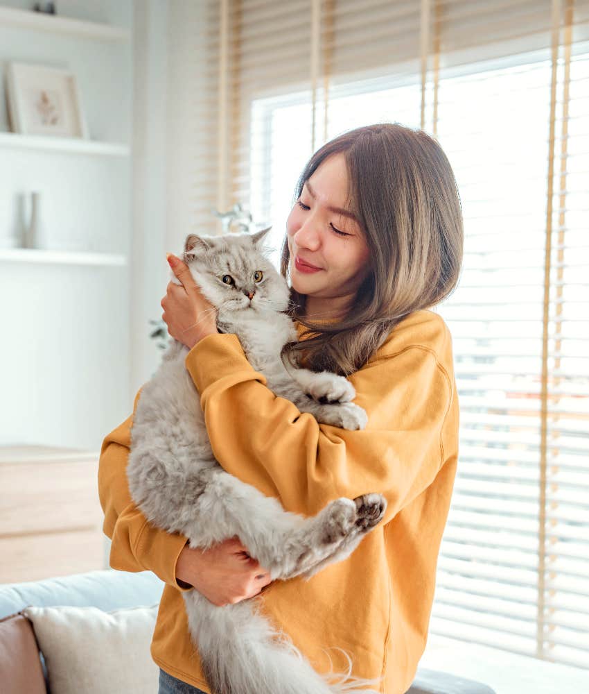 woman holding well behaved cat
